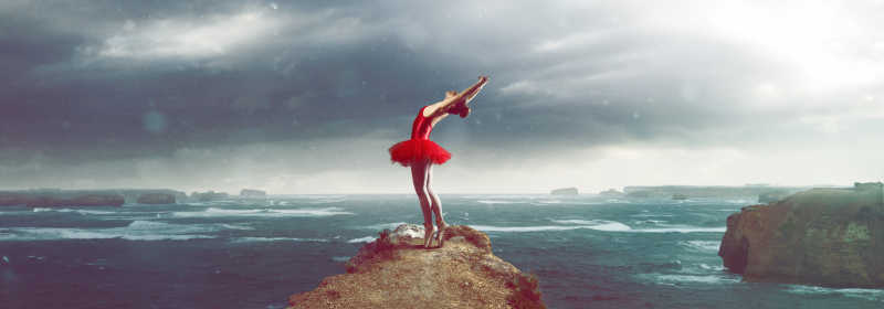在暴风雨的海洋景观面前的芭蕾舞演员