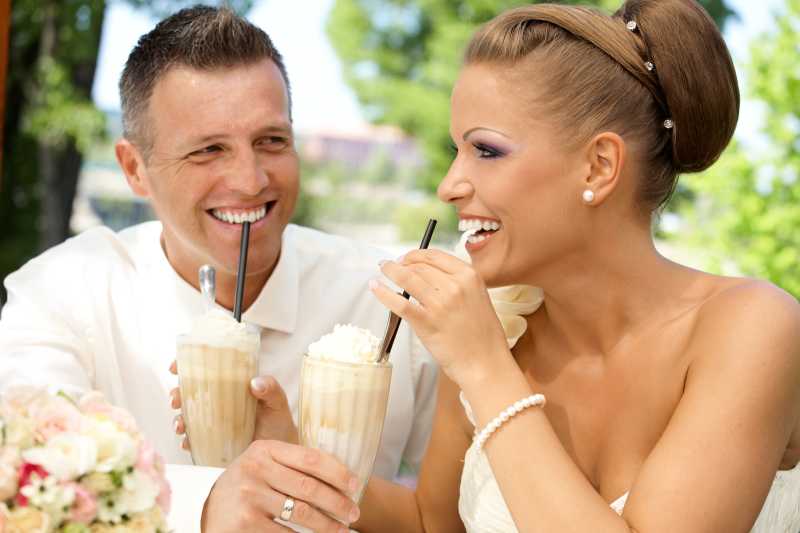 幸福的夫妇在婚礼当天喝冰咖啡