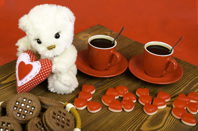 两杯咖啡饼干还有一只泰迪熊