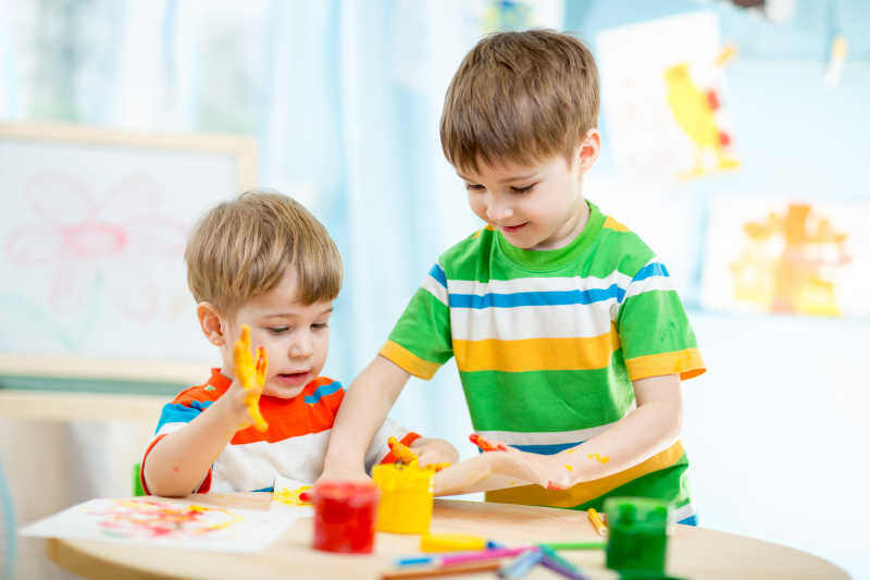 两个孩子在幼儿园或托儿所玩耍和绘画