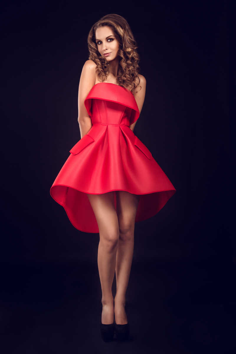 时尚性感的穿着红色晚礼服的年轻模特