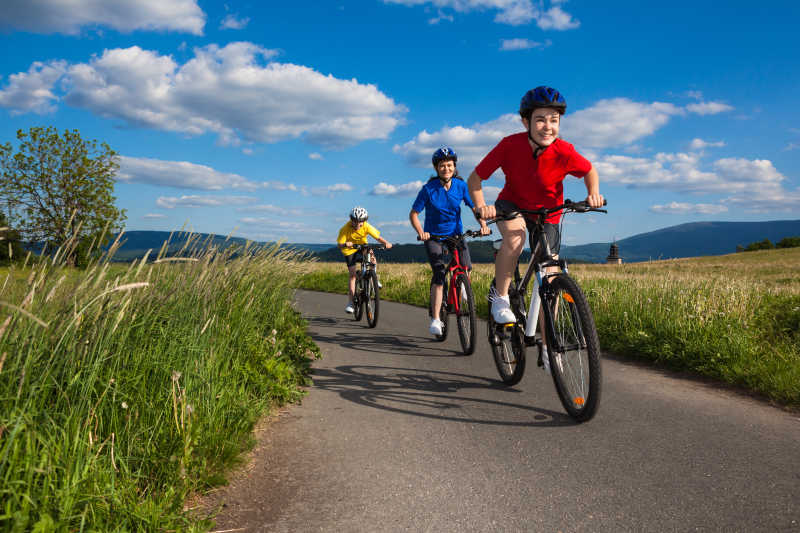 乡间道路上的三人家庭自行车骑行