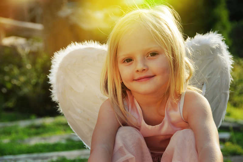 美丽的小女孩戴着天使的翅膀