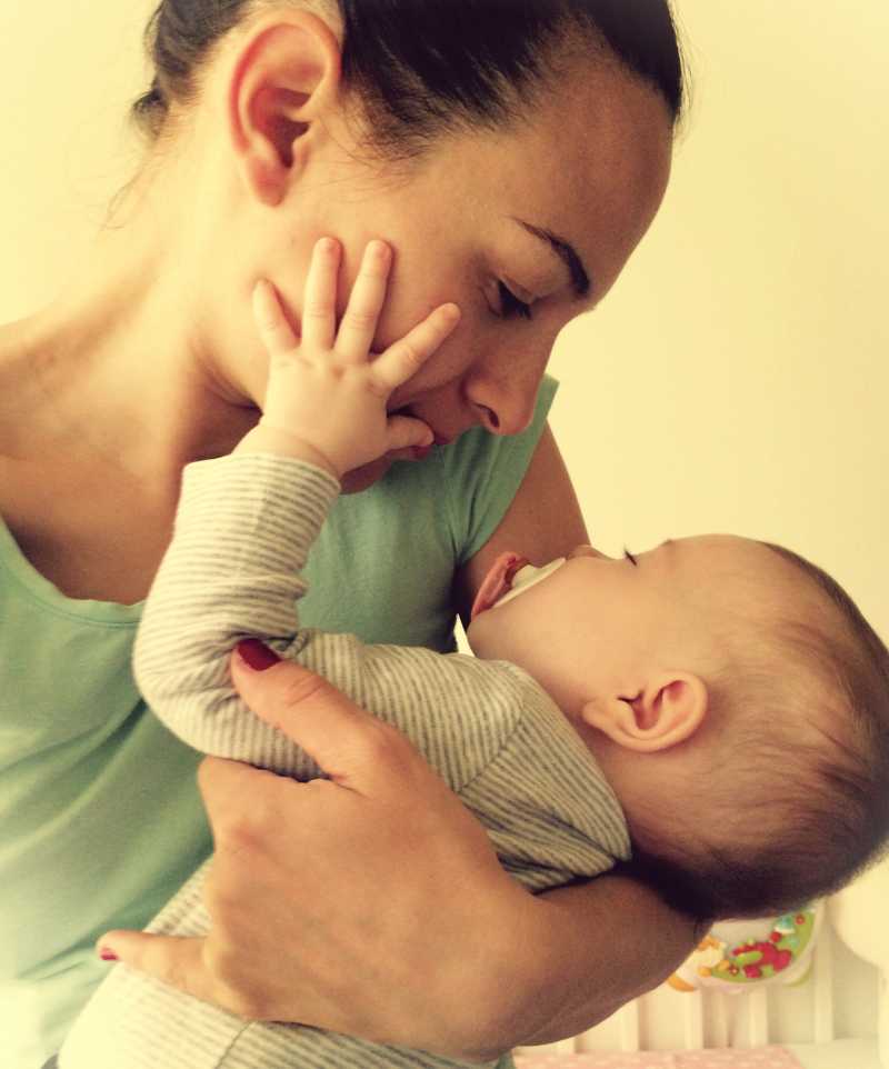 嗷嗷待哺的婴儿抚摸着妈妈的脸