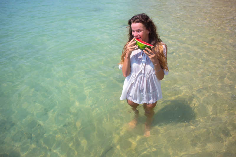 站在海水里吃西瓜的女孩特写
