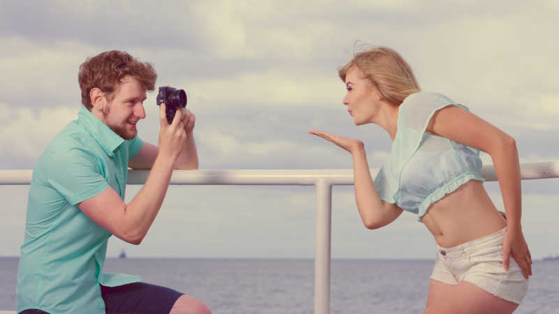 年轻情侣在码头上拍照