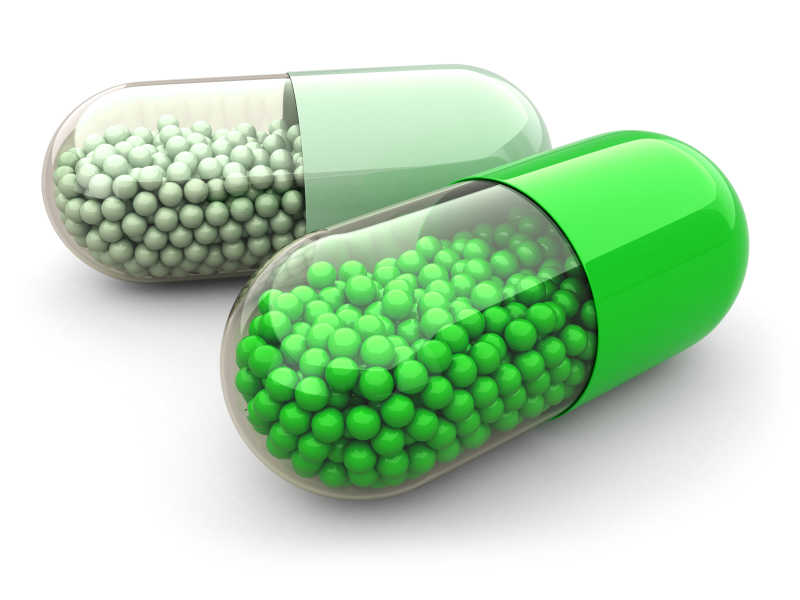 绿色背景上的白色隔离丸和药品结论医学