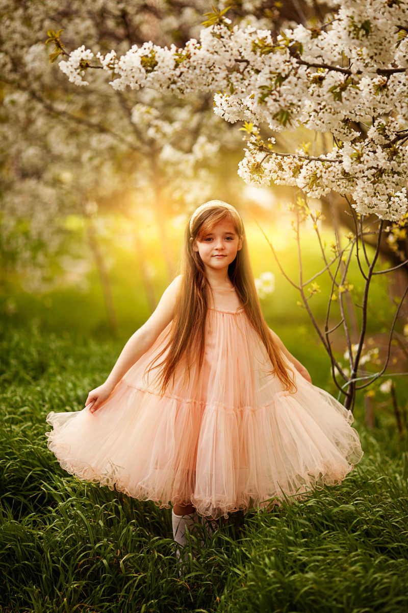 春天花园里可爱的小女孩的裙子