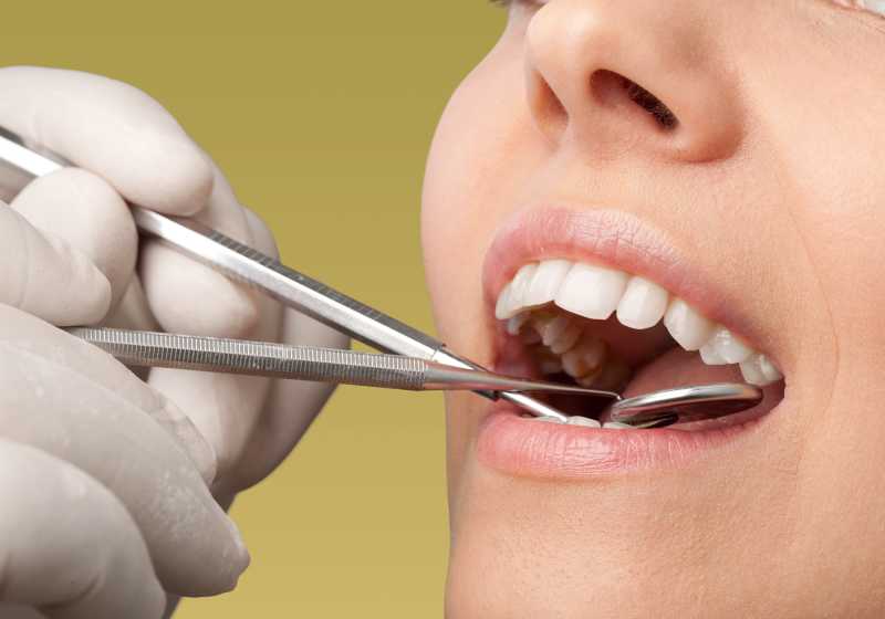 牙医通过辅助工具做牙齿检查