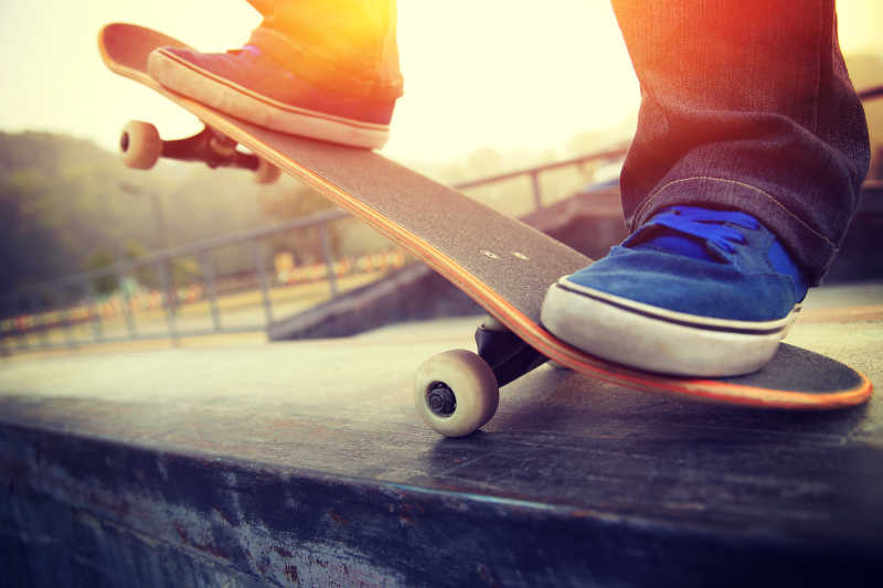 夕阳下玩滑板的年轻人