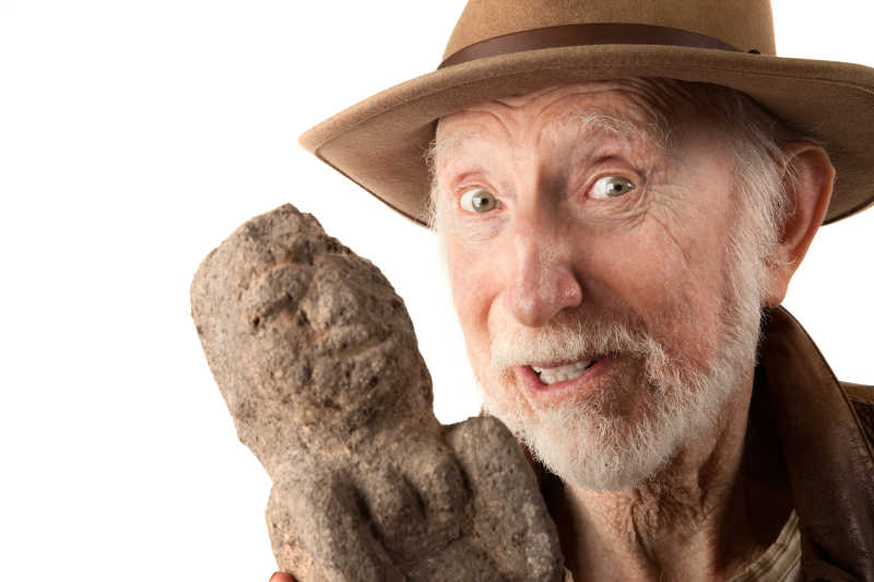 考古教授手里拿着石头人偶