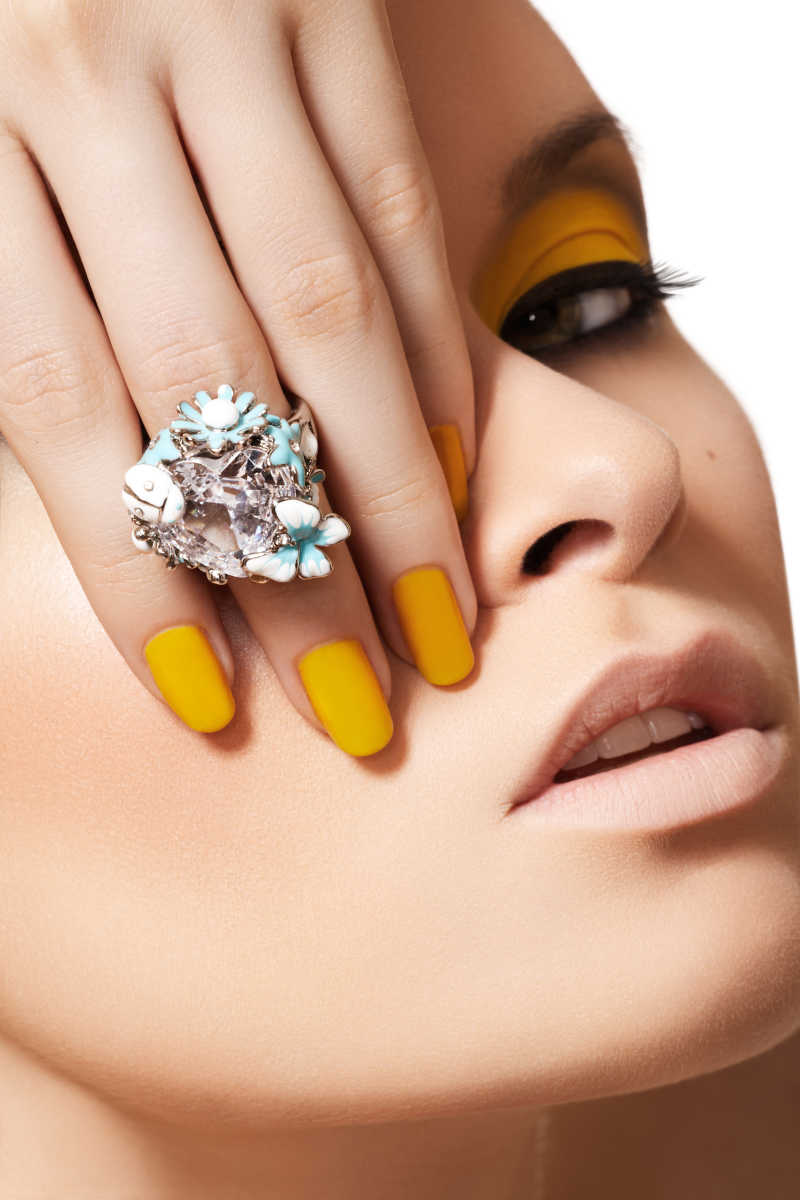黄色的时尚化妆和大水晶戒指模特