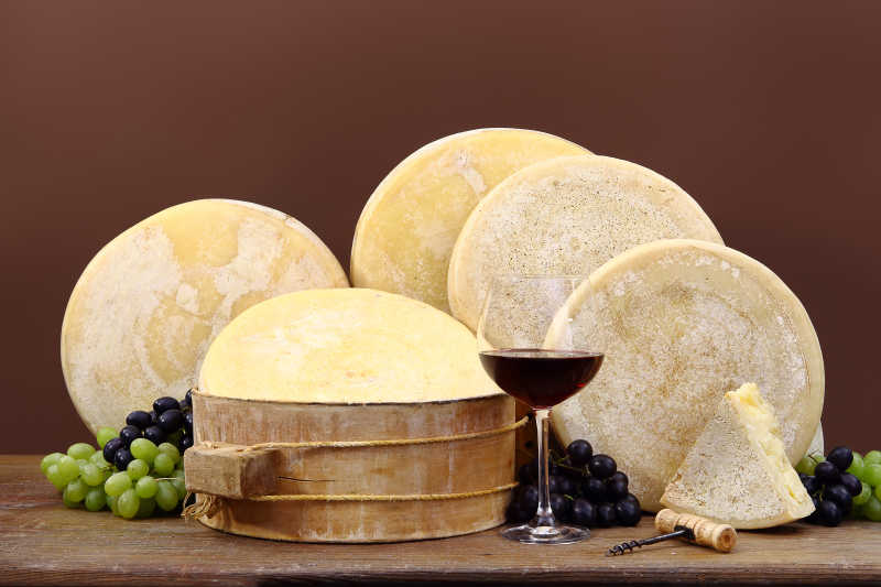 木桌上的圆形的奶酪和葡萄酒