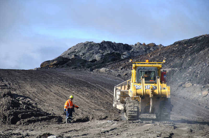 煤场上采煤的推土机和矿工