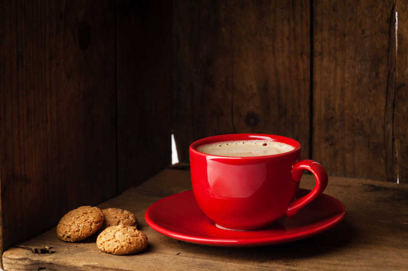 红色咖啡杯里的咖啡和饼干