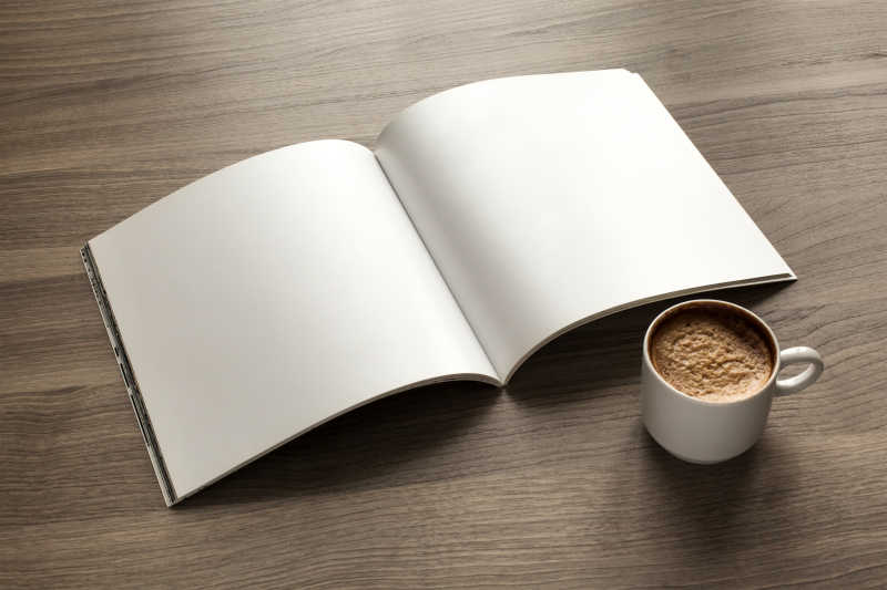 木色桌面上打开的白色封面的日记本