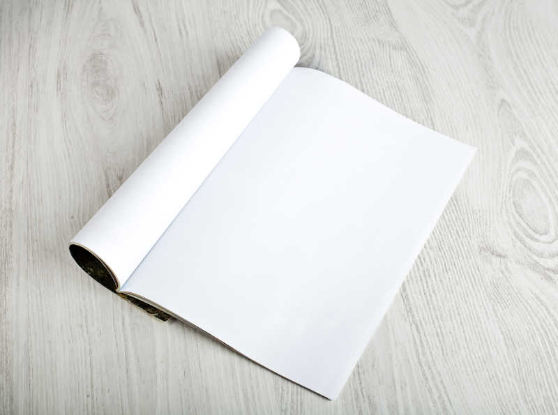 白色木制桌面上打开空白页的杂志