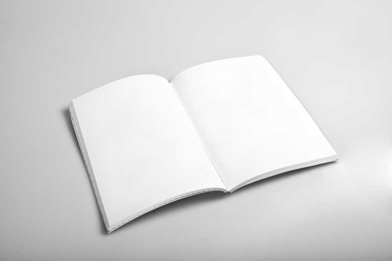 灰白色桌面上打开的空白日记本