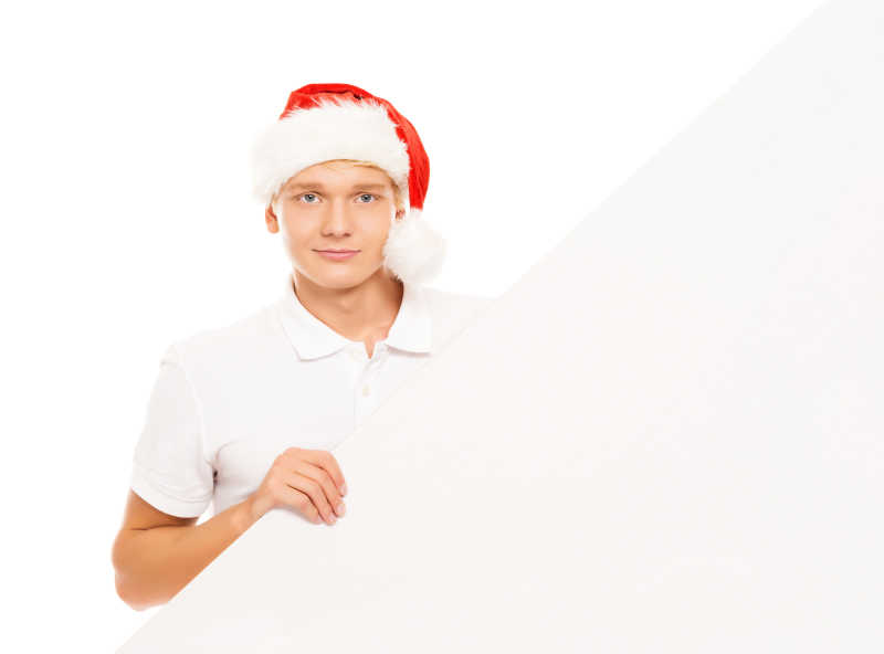 拿着空白横幅戴着红色圣诞帽的年轻人