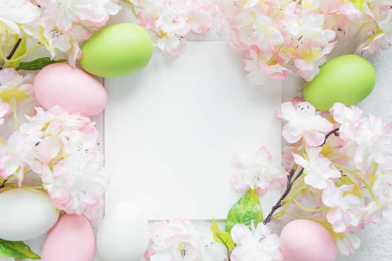 白色背景上的彩色复活节彩蛋和樱花花枝