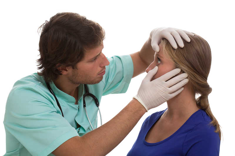 外科医生正在给女患者检查眼睛