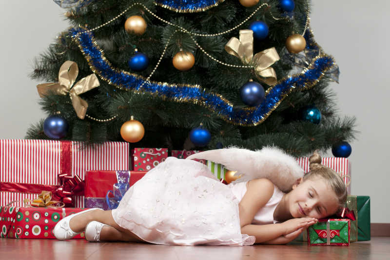 圣诞树下睡着的小女孩天使