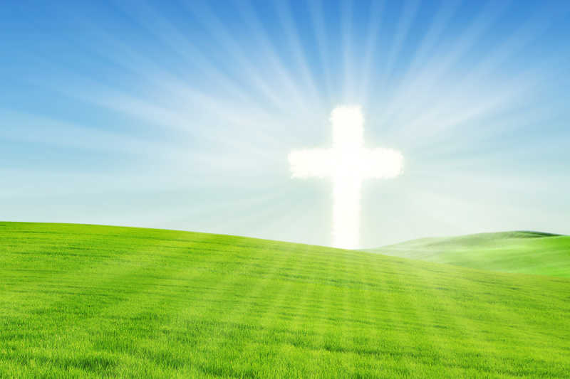 草地上散发着光芒的十字架