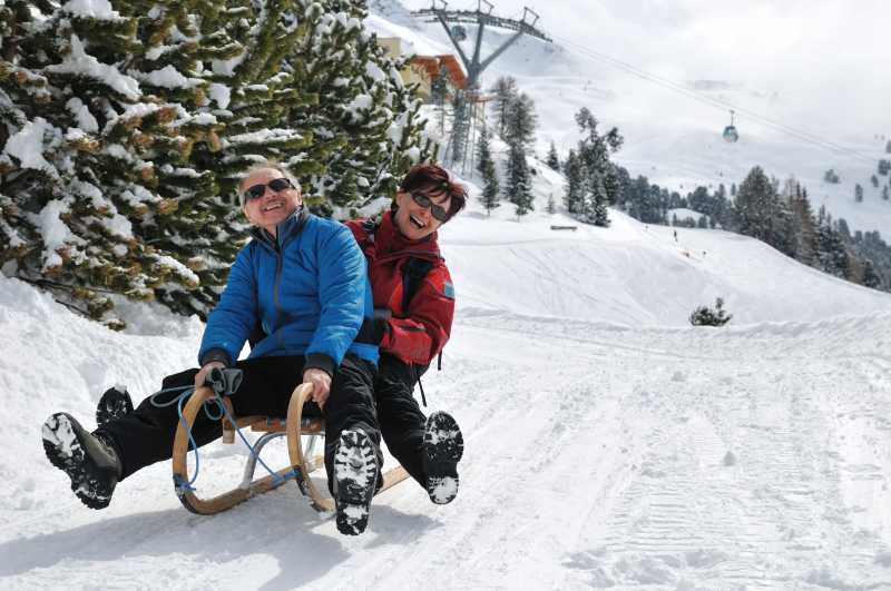 雪橇上活跃的老夫妇在雪山国家玩得开心