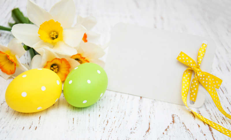 白色背景下的复活节彩蛋和水仙花贺卡