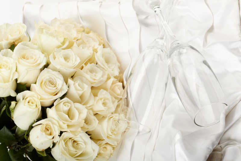 白色床单上整齐摆放的奶油玫瑰