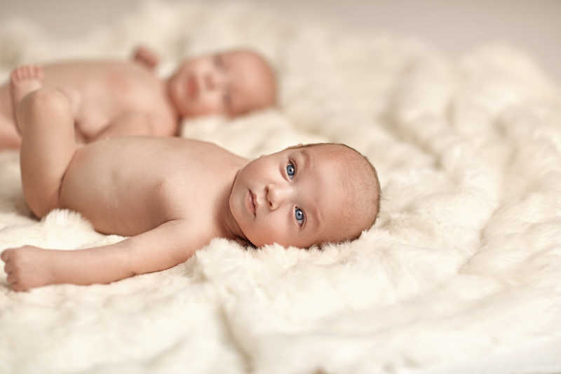 躺在白毯子上地双胞胎婴儿