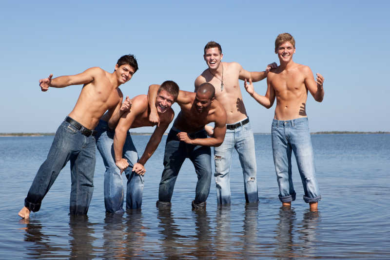 5个男人穿着牛仔裤站在水中