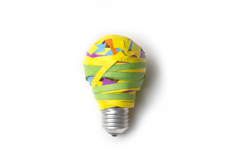 许多不同色彩的纸条在灯泡上作为创意想法概念