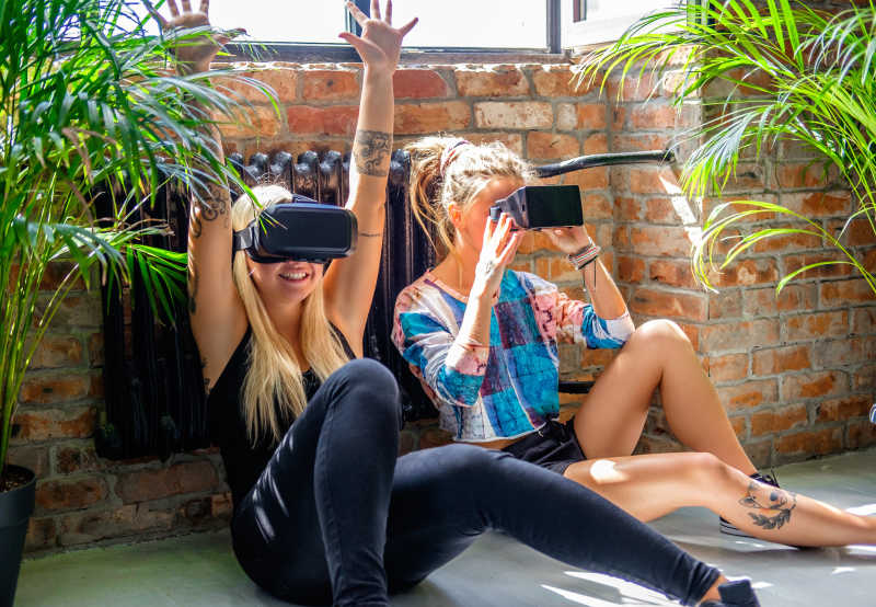 靠在墙壁上玩VR眼镜的女性