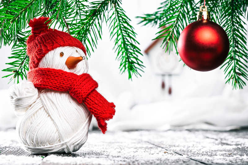 手工编织的雪人红色圣诞球在常青树枝下152231602411