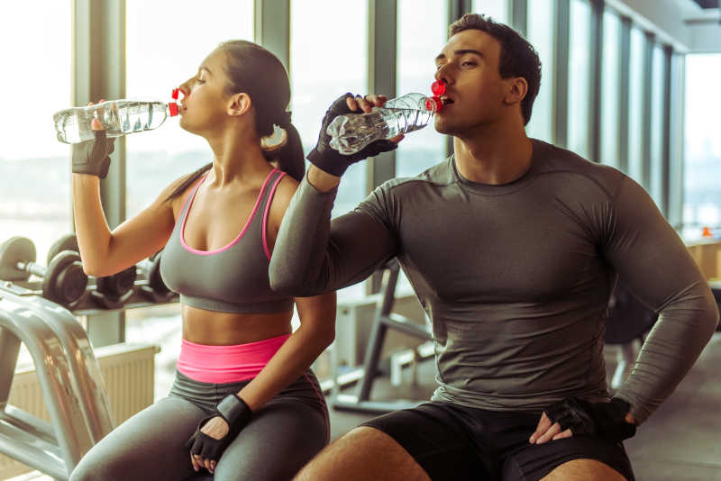 健身房里正在喝水的健身男女