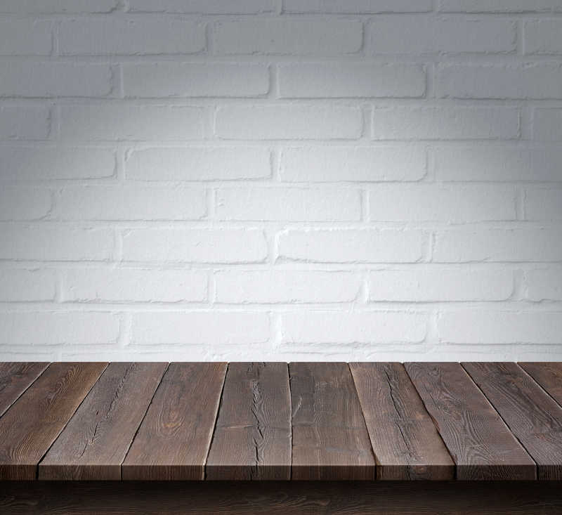 白色砖墙背景下的木桌