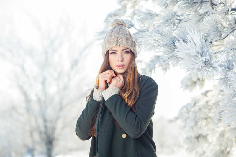 站在美丽的冬日雪景中的年轻女子