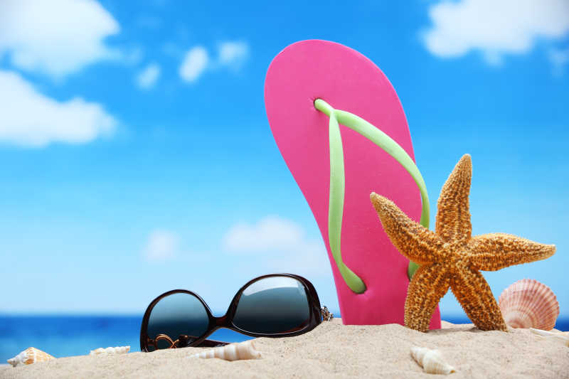 海滩边的墨镜沙滩鞋和海星