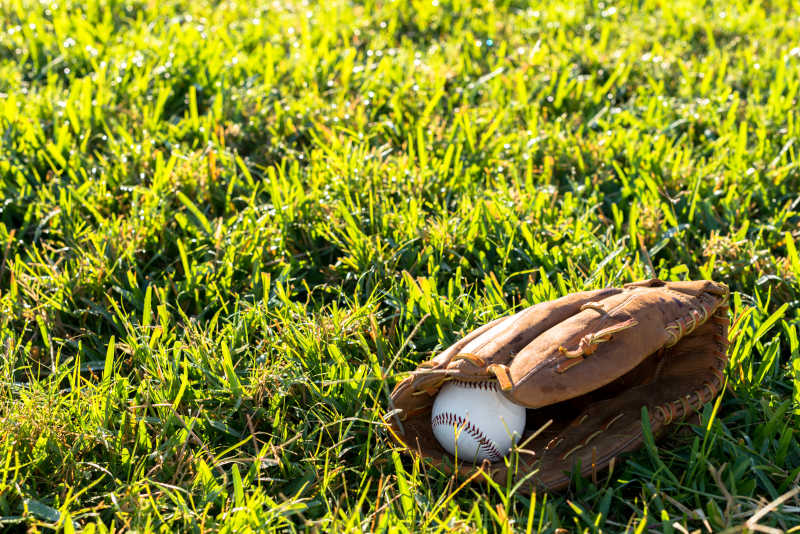 草地上的棒球手套和棒球