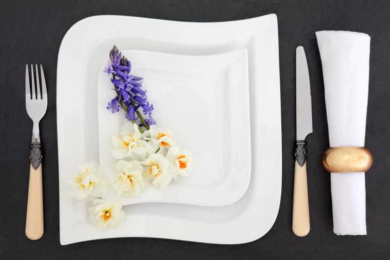 深色桌面上的餐具和花朵
