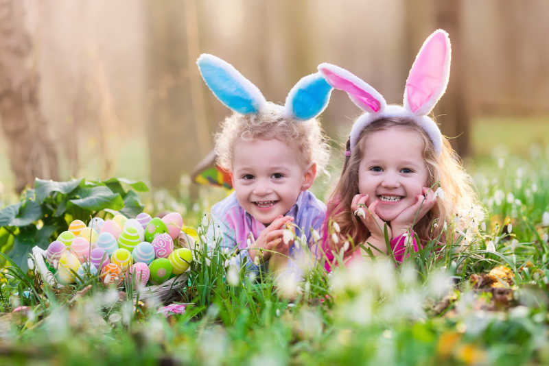 趴在草地里上两个小孩与复活节彩蛋