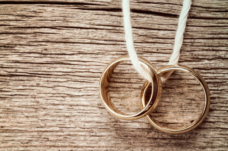 挂在木制背景上的结婚戒指