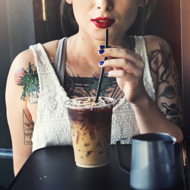 喝冰咖啡放松的纹身美女