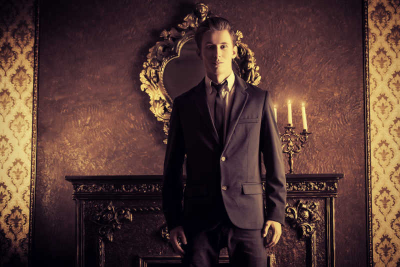 穿着典雅西装的英俊男人站在古典风格的房间里
