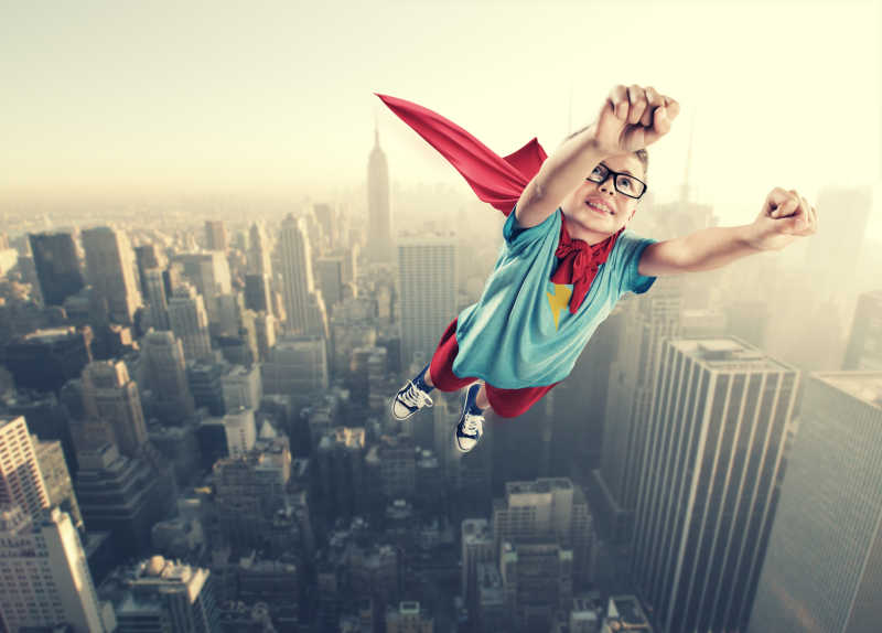 孩子穿着超人服装想象自己像超级英雄一样在空中飞行