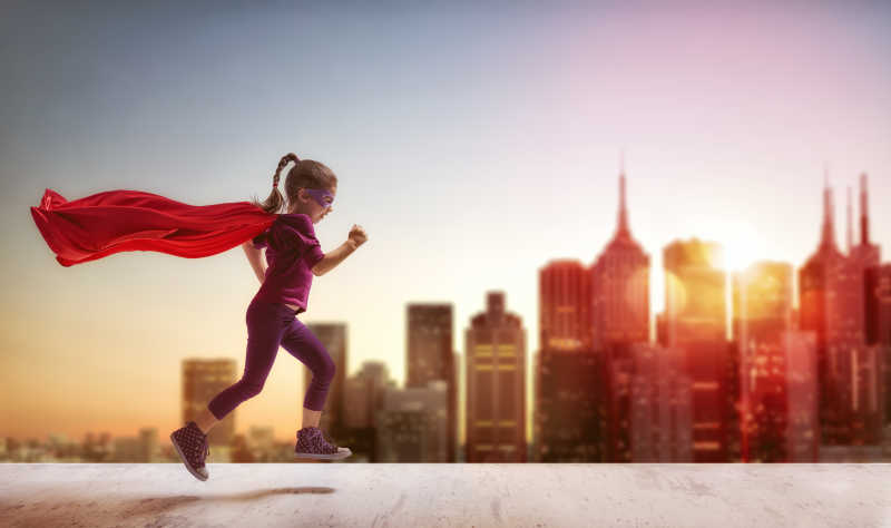 在早晨穿着超级英雄服装的女孩在跑步