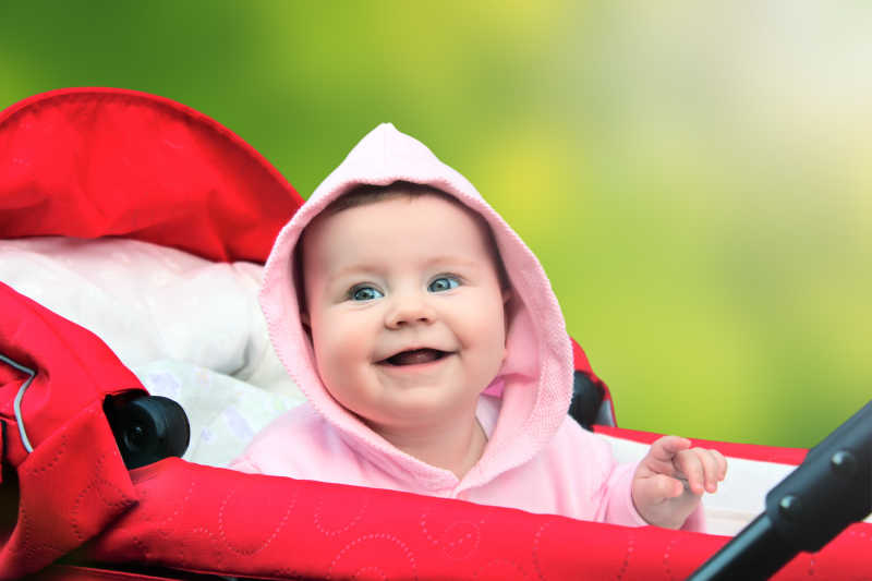 微笑可爱的婴儿坐在婴儿车上