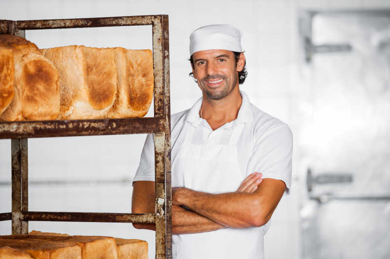 面包架子前微笑的男人