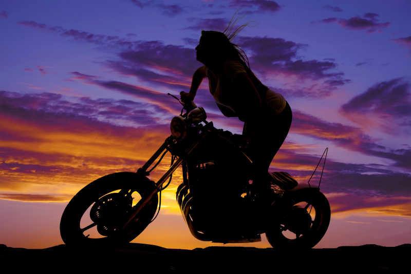 夕阳下骑摩托车的女人剪影